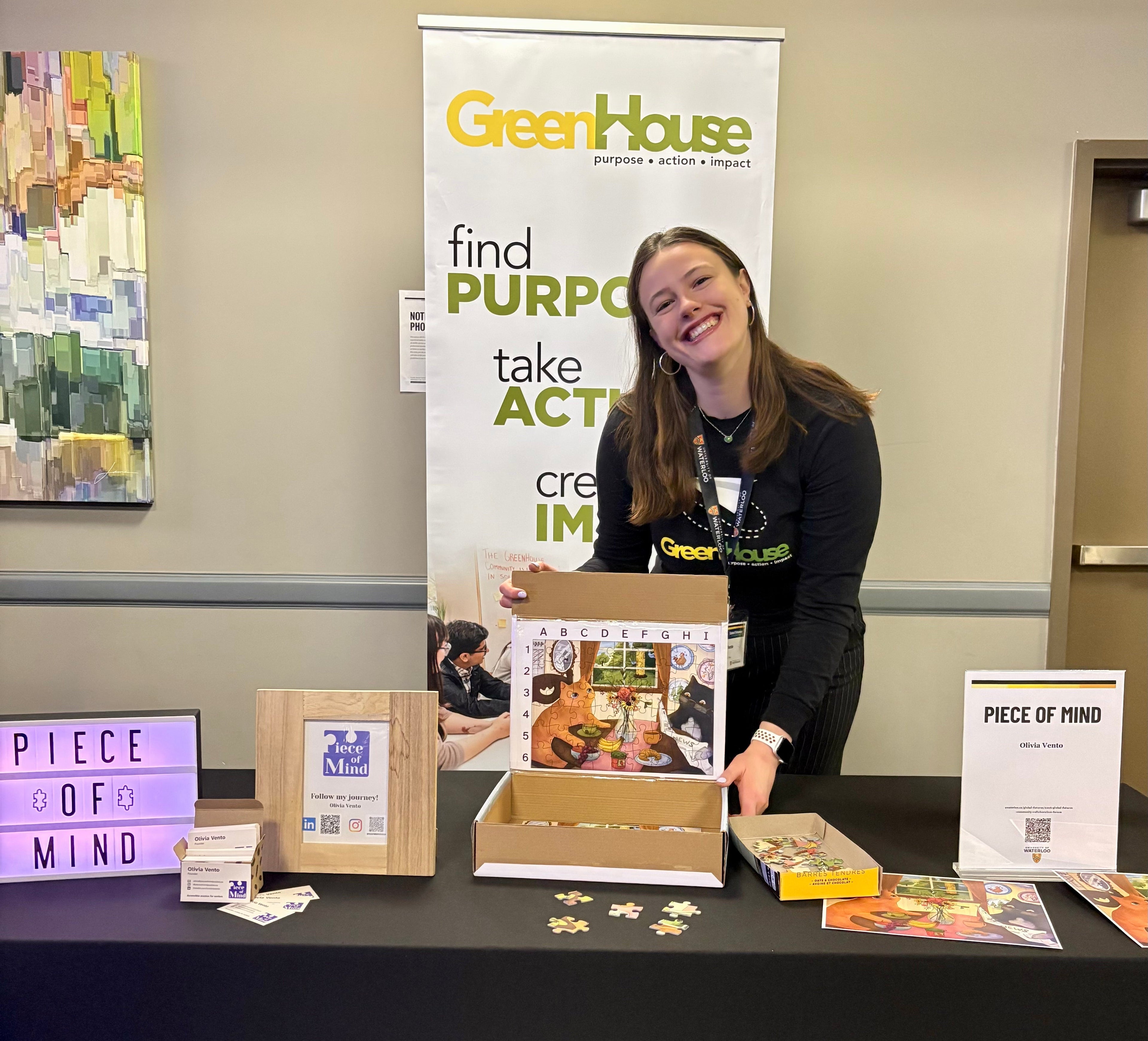 Olivia at a conference booth with an early puzzle prototype