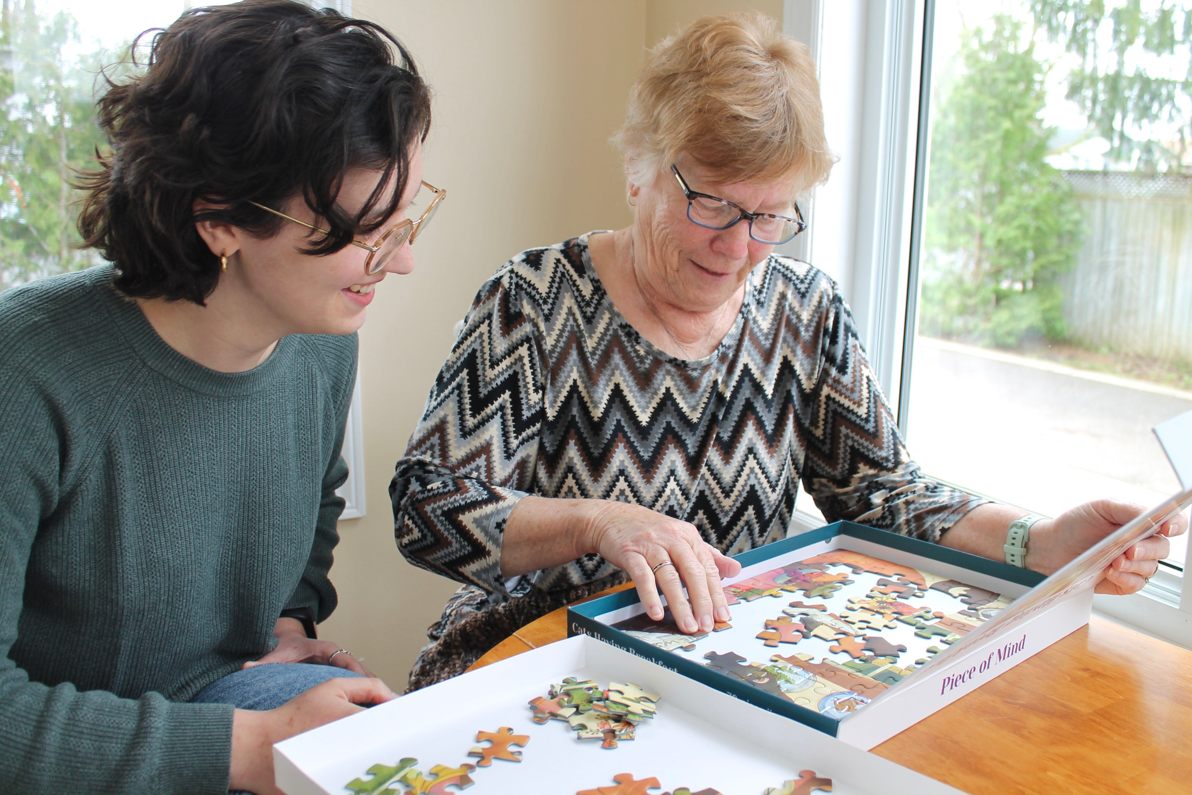 Two people working on a puzzle together at a table.